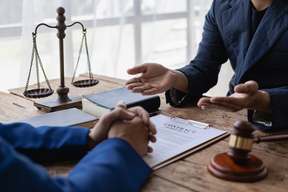 Lawyers discussing contracts or business deals at a law firm. Justice service concept with close-up of a gavel and scales side by side.