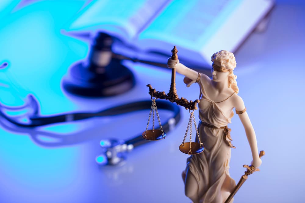 Legal and medical elements - gavel, stethoscope, and blue light. Space for text.