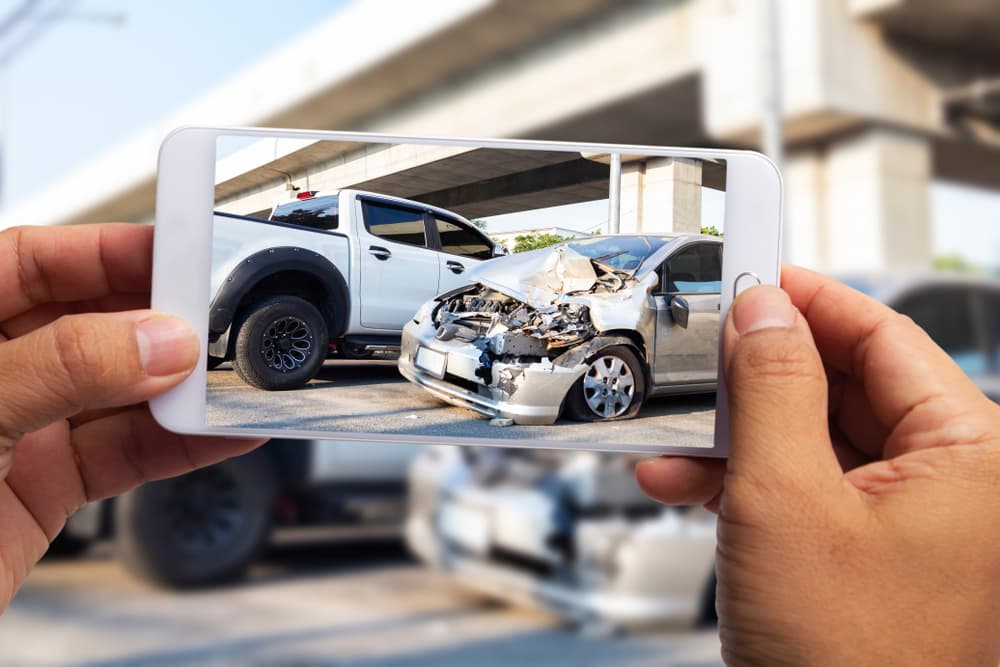Car insurance agents use smartphones to capture images of vehicles damaged in accidents as evidence for insurance claims.






