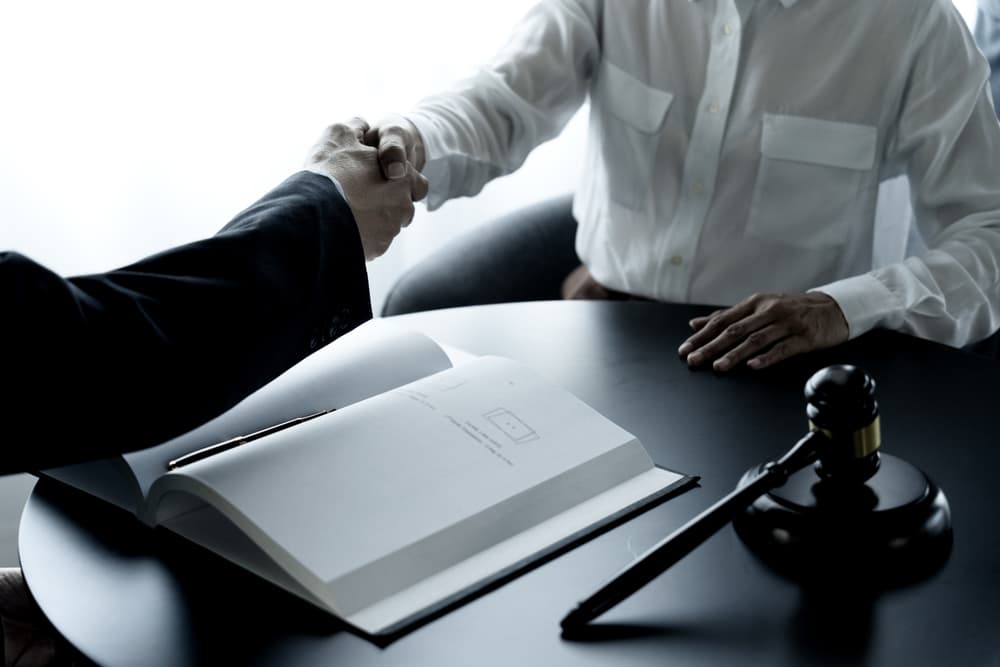 Lawyer shaking hands in a law firm, signifying a legal agreement