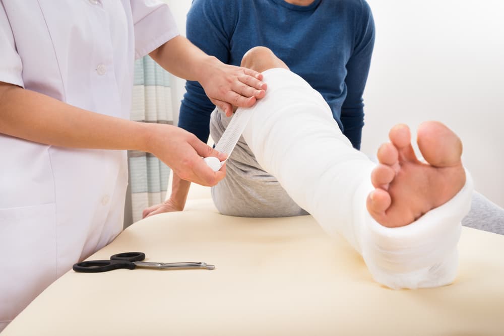 Female Doctor Bandaging Patient's Leg