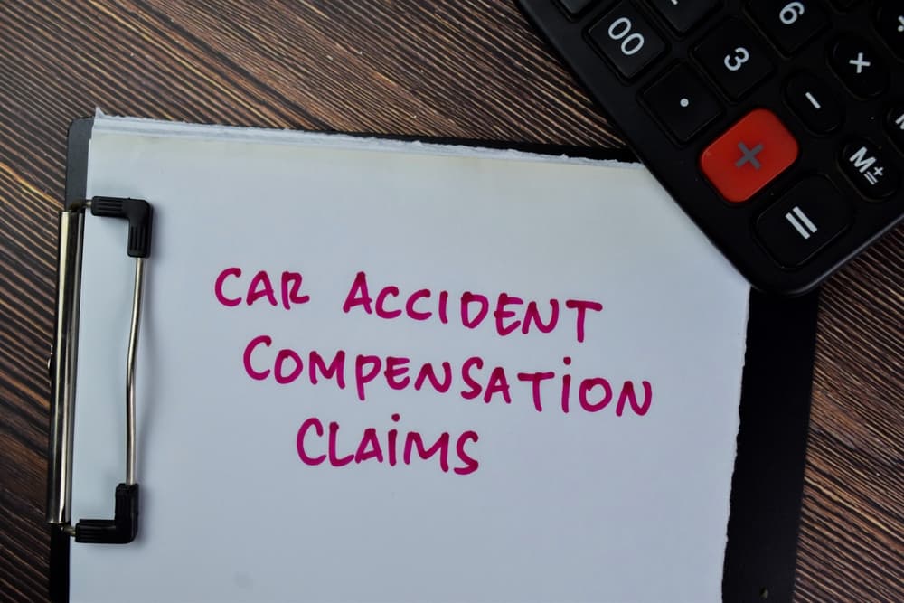 Car accident compensation claims concept written on paperwork, isolated on wooden table.