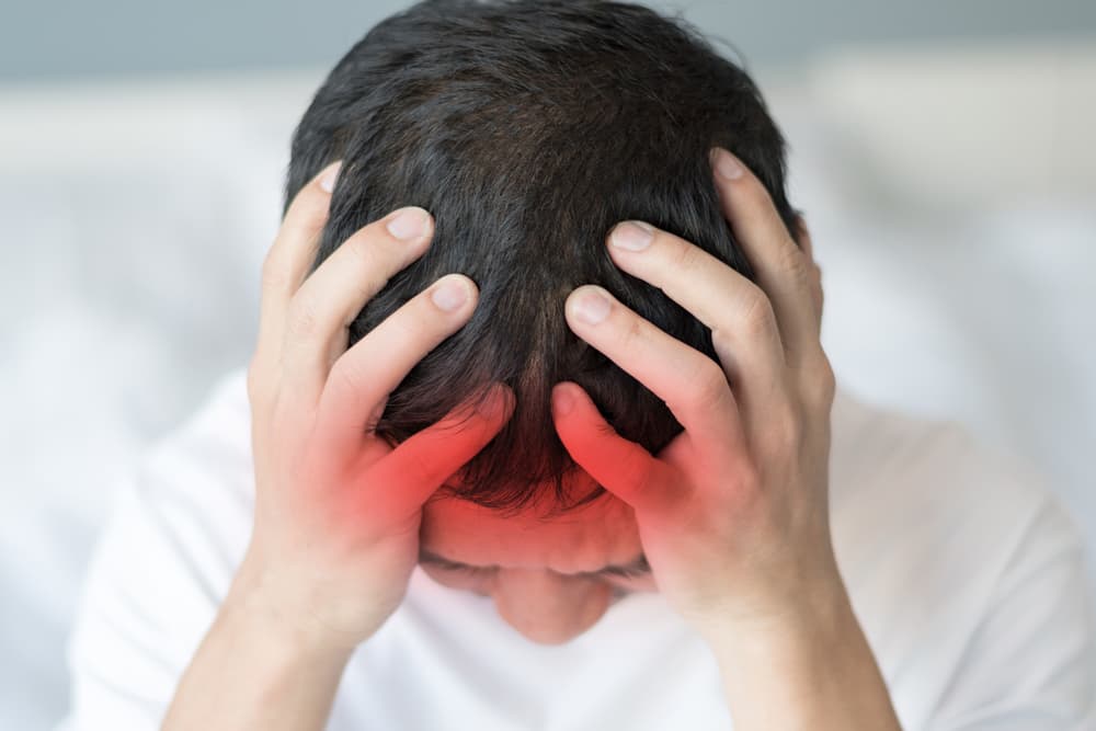 Adult male experiencing severe migraine headache, showing signs of stress and discomfort, medical condition concept